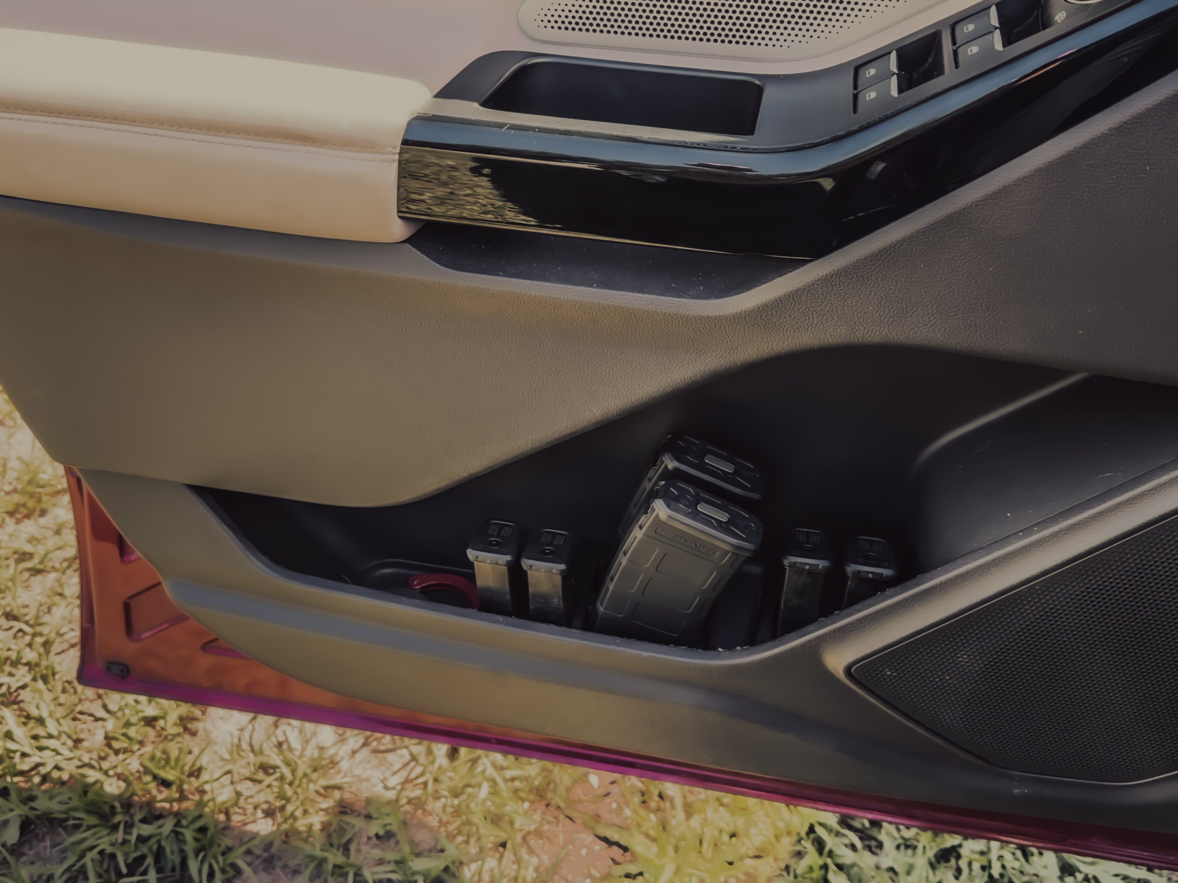 Close-up of a car's undercarriage with visible components on a grassy background